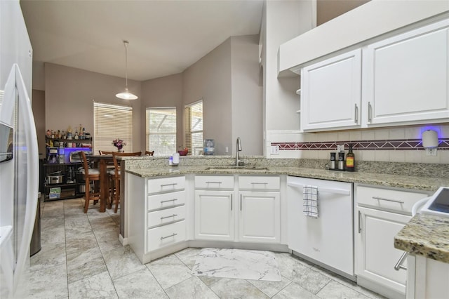 6918 Potomac Cir, Riverview, FL 33578 - kitchen with white dishwasher, a sink, a peninsula, white cabinets, and light marble finish floors