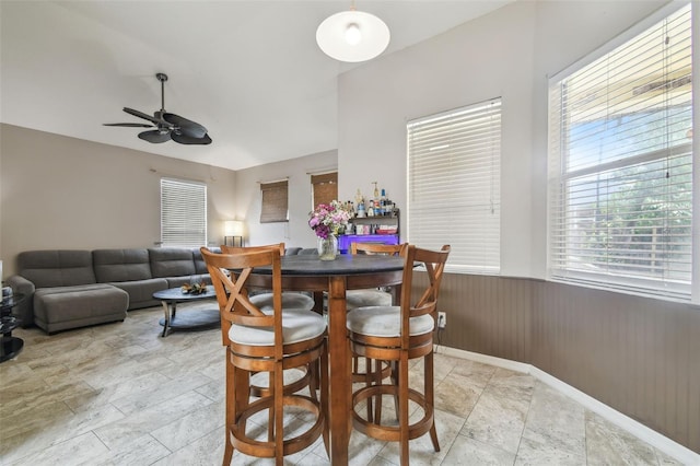 6918 Potomac Cir, Riverview, FL 33578 - dining space featuring ceiling fan, a wainscoted wall, baseboards, wooden walls, and light stone finish floors