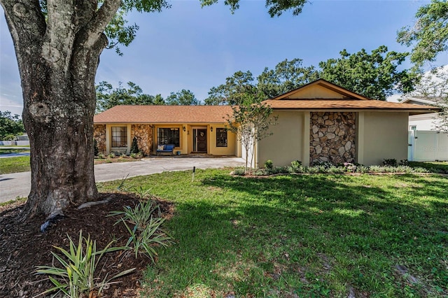 3041 Oak View Dr, Palm Harbor, FL 34684 - ranch-style house with stone siding, a front lawn, driveway, and stucco siding