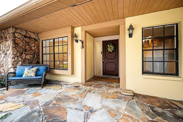 3041 Oak View Dr, Palm Harbor, FL 34684 - doorway to property featuring stucco siding, covered porch, and stone siding