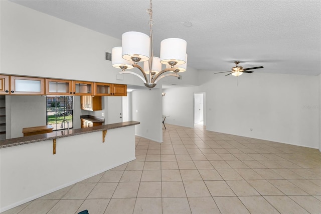 3041 Oak View Dr, Palm Harbor, FL 34684 - kitchen with brown cabinetry, ceiling fan, a textured ceiling, glass insert cabinets, and dark stone countertops