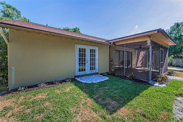 3041 Oak View Dr, Palm Harbor, FL 34684 - back of house with a sunroom, stucco siding, a lawn, and french doors