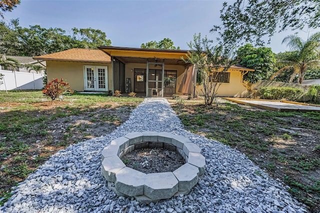 3041 Oak View Dr, Palm Harbor, FL 34684 - rear view of house with french doors, stucco siding, and an outdoor fire pit