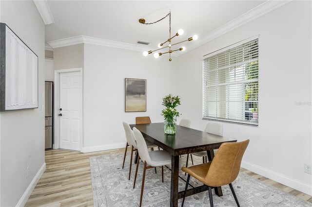 8518 Tidal Bay Ln, Tampa, FL 33635 - dining area with light wood-type flooring, crown molding, a chandelier, and baseboards
