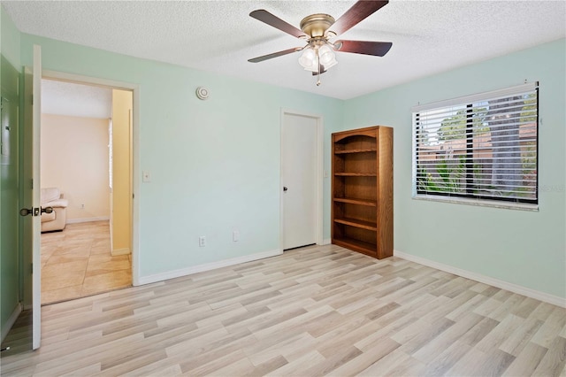 8436 60th St N Unit 304, Pinellas Park, FL 33781 - unfurnished room featuring light wood-style floors, a ceiling fan, a textured ceiling, and baseboards