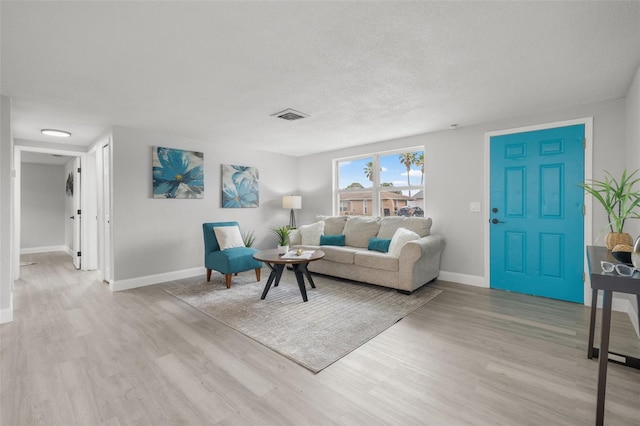 6804 Tierra Verde St, Port Richey, FL 34668 - living room with light wood-style flooring, baseboards, and a textured ceiling