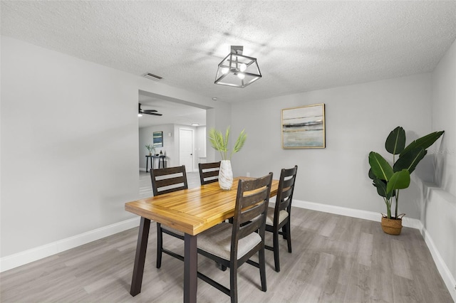 6804 Tierra Verde St, Port Richey, FL 34668 - dining space with wood finished floors, a textured ceiling, and baseboards