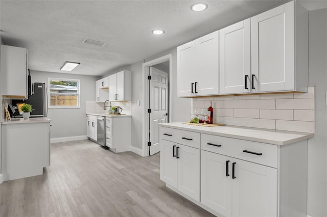 6804 Tierra Verde St, Port Richey, FL 34668 - kitchen featuring tasteful backsplash, a textured ceiling, baseboards, light countertops, and light wood-type flooring