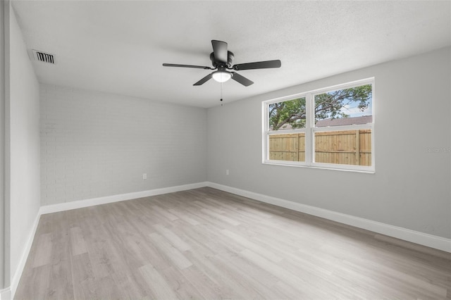 6804 Tierra Verde St, Port Richey, FL 34668 - spare room with wood finished floors, baseboards, a ceiling fan, and brick wall