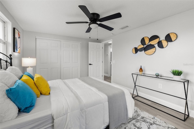 6804 Tierra Verde St, Port Richey, FL 34668 - bedroom with wood finished floors, a closet, a ceiling fan, and baseboards