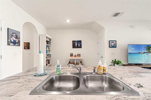 2925 Evergreen Elm Pass, Wesley Chapel, FL 33543 - kitchen featuring a sink, arched walkways, light stone counters, and recessed lighting