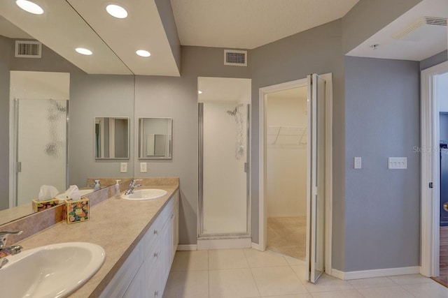 960 Starkey Rd Unit 2405, Largo, FL 33771 - full bathroom with a shower stall, a spacious closet, baseboards, tile patterned flooring, and double vanity