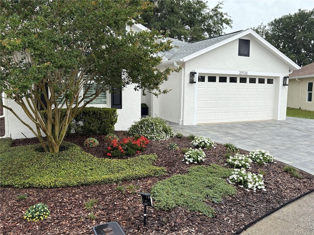 20938 Sunsweet Ct, Land O Lakes, FL 34637 - view of front of home with a garage, stucco siding, and decorative driveway