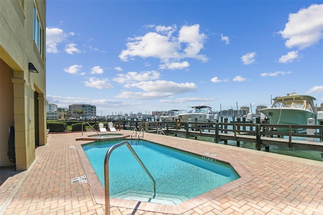 200 Skiff Pt Unit 202, Clearwater Beach, FL 33767 - view of swimming pool with a dock, boat lift, a patio area, and a pool with connected hot tub