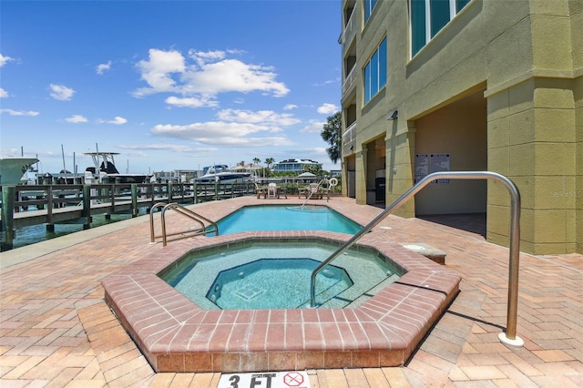 200 Skiff Pt Unit 202, Clearwater Beach, FL 33767 - community pool featuring a hot tub, a patio area, and a dock