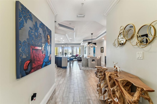 200 Skiff Pt Unit 202, Clearwater Beach, FL 33767 - hallway with crown molding, light wood-style floors, a tray ceiling, a chandelier, and baseboards