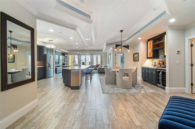 200 Skiff Pt Unit 202, Clearwater Beach, FL 33767 - dining space with wine cooler, a tray ceiling, ornamental molding, bar area, and light wood-style flooring