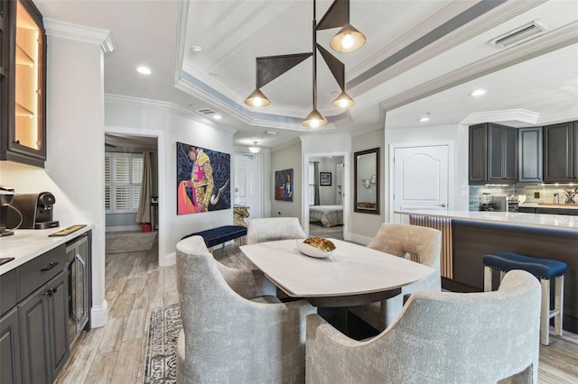 200 Skiff Pt Unit 202, Clearwater Beach, FL 33767 - dining area with baseboards, crown molding, recessed lighting, a tray ceiling, and beverage cooler