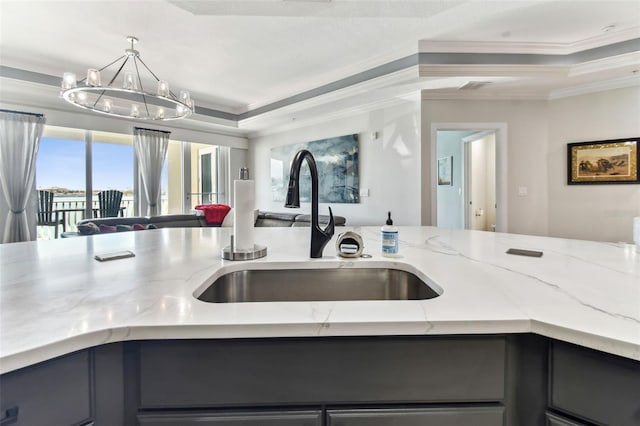 200 Skiff Pt Unit 202, Clearwater Beach, FL 33767 - kitchen featuring a sink, crown molding, open floor plan, gray cabinetry, and light stone counters