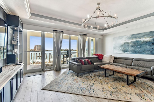 200 Skiff Pt Unit 202, Clearwater Beach, FL 33767 - living room featuring a tray ceiling, crown molding, a chandelier, and light wood-type flooring