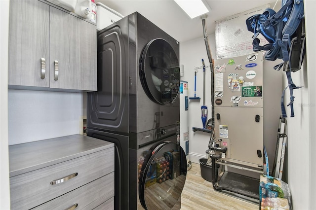 200 Skiff Pt Unit 202, Clearwater Beach, FL 33767 - laundry room featuring stacked washer / dryer, cabinet space, and wood finished floors