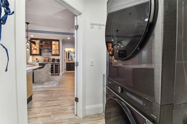 200 Skiff Pt Unit 202, Clearwater Beach, FL 33767 - laundry area with stacked washer / dryer, light wood-type flooring, baseboards, wine cooler, and recessed lighting