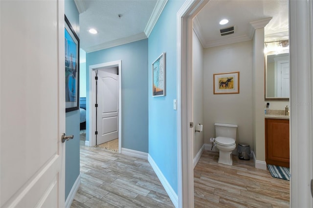200 Skiff Pt Unit 202, Clearwater Beach, FL 33767 - bathroom featuring ornamental molding, toilet, vanity, wood finished floors, and baseboards