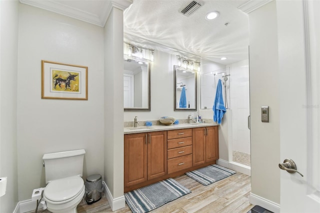 200 Skiff Pt Unit 202, Clearwater Beach, FL 33767 - full bathroom featuring toilet, a shower stall, double vanity, wood finished floors, and crown molding