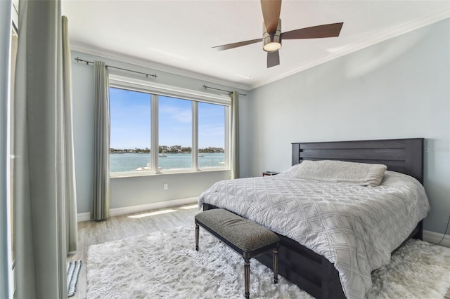 200 Skiff Pt Unit 202, Clearwater Beach, FL 33767 - bedroom with crown molding, baseboards, wood finished floors, ceiling fan, and a water view