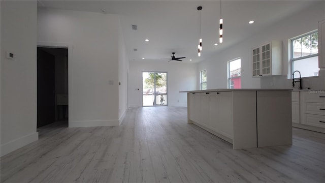 7011 N 15th St, Tampa, FL 33610 - kitchen with white cabinetry, light wood-style floors, plenty of natural light, a sink, and recessed lighting