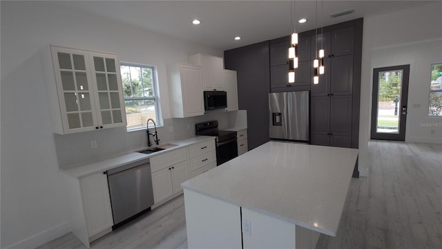7011 N 15th St, Tampa, FL 33610 - kitchen with appliances with stainless steel finishes, a sink, light wood-type flooring, plenty of natural light, and recessed lighting