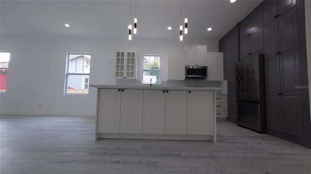 7011 N 15th St, Tampa, FL 33610 - kitchen with fridge with ice dispenser, stainless steel microwave, light wood-style flooring, baseboards, and white cabinetry