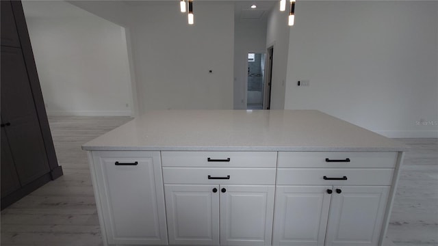 7011 N 15th St, Tampa, FL 33610 - kitchen featuring white cabinets, decorative light fixtures, light wood-style flooring, and a kitchen island