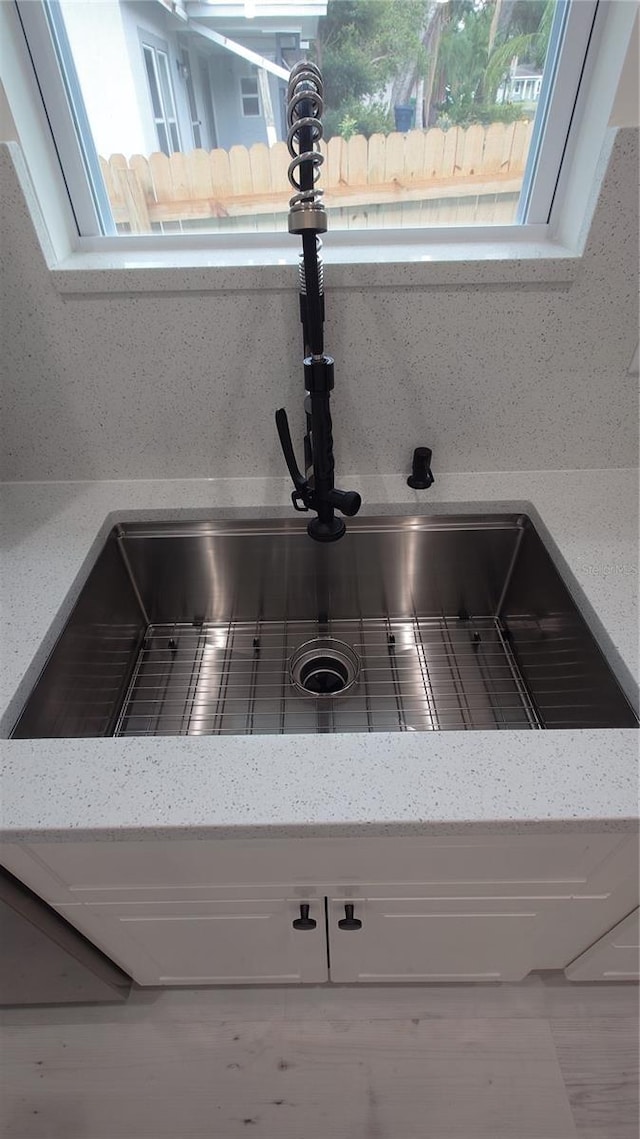 7011 N 15th St, Tampa, FL 33610 - kitchen view of a sink, light stone counters, and white cabinetry