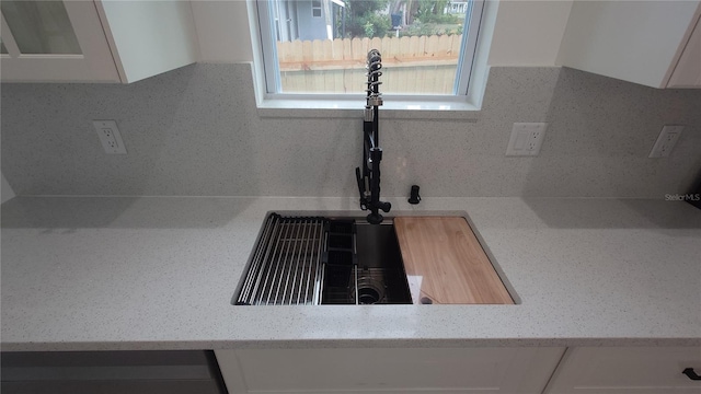 7011 N 15th St, Tampa, FL 33610 - kitchen view of white cabinetry, a sink, tasteful backsplash, and glass insert cabinets