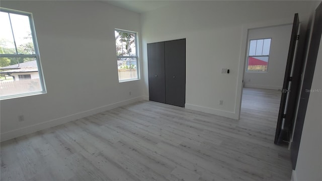 7011 N 15th St, Tampa, FL 33610 - unfurnished bedroom featuring light wood-type flooring, baseboards, and a closet