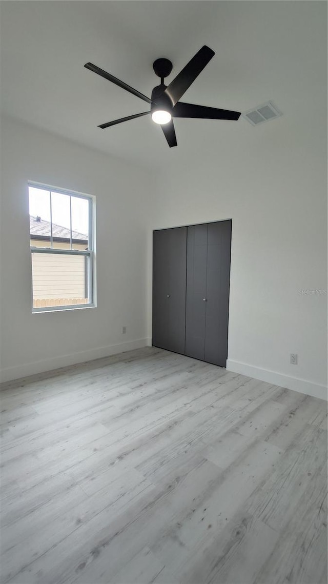 7011 N 15th St, Tampa, FL 33610 - unfurnished bedroom with light wood-type flooring, a closet, baseboards, and ceiling fan