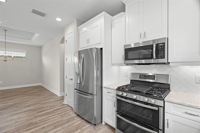 11354 Callisia Dr, Odessa, FL 33556 - kitchen featuring stainless steel appliances, backsplash, baseboards, light wood finished floors, and white cabinets