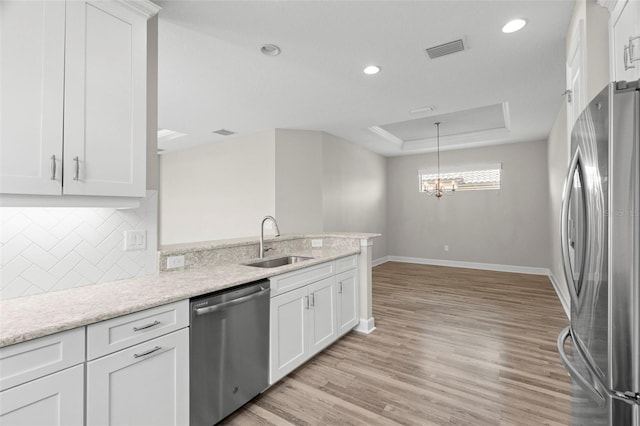 11354 Callisia Dr, Odessa, FL 33556 - kitchen featuring appliances with stainless steel finishes, a sink, baseboards, backsplash, and a peninsula
