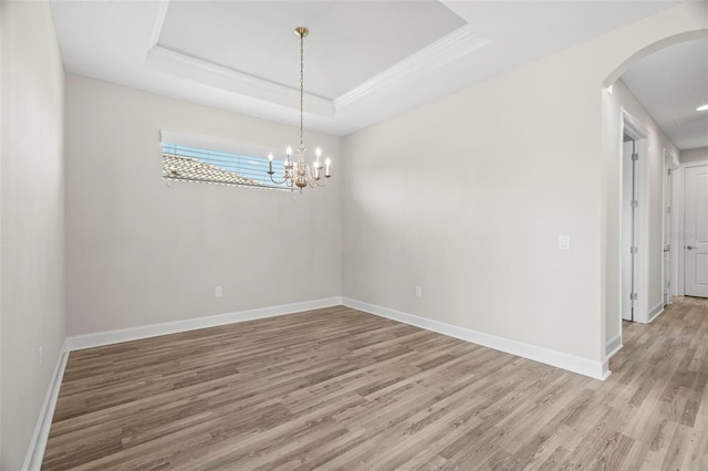 11354 Callisia Dr, Odessa, FL 33556 - unfurnished room featuring arched walkways, light wood finished floors, baseboards, a tray ceiling, and ornamental molding