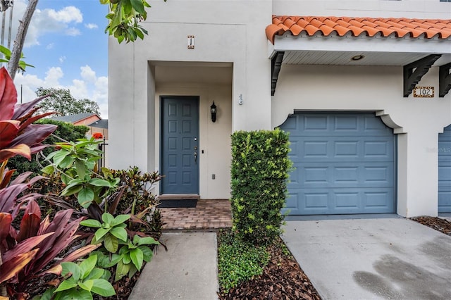102 S Moody Ave Unit 1, Tampa, FL 33609 - entrance to property featuring stucco siding, a tiled roof, concrete driveway, and a garage