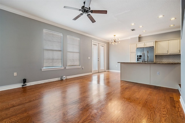 102 S Moody Ave Unit 1, Tampa, FL 33609 - unfurnished living room with a chandelier, ornamental molding, a ceiling fan, recessed lighting, and wood finished floors