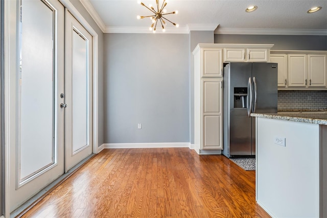 102 S Moody Ave Unit 1, Tampa, FL 33609 - kitchen featuring stainless steel fridge with ice dispenser, a chandelier, light wood-type flooring, tasteful backsplash, and baseboards