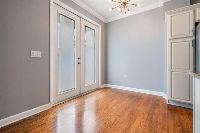 102 S Moody Ave Unit 1, Tampa, FL 33609 - spare room featuring french doors, a chandelier, ornamental molding, wood finished floors, and baseboards
