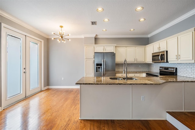 102 S Moody Ave Unit 1, Tampa, FL 33609 - kitchen featuring appliances with stainless steel finishes, a sink, dark stone counters, a peninsula, and french doors