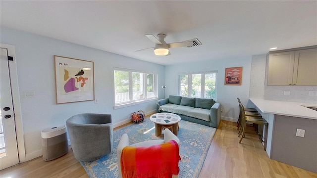 1200 47th St N, Saint Petersburg, FL 33713 - living area with ceiling fan, light wood-style floors, and baseboards