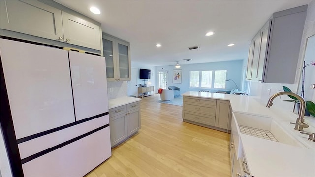 1200 47th St N, Saint Petersburg, FL 33713 - kitchen featuring gray cabinets, freestanding refrigerator, light wood-style floors, light countertops, and recessed lighting