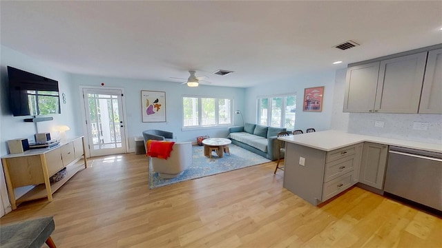 1200 47th St N, Saint Petersburg, FL 33713 - kitchen featuring gray cabinets, stainless steel dishwasher, open floor plan, light countertops, and light wood finished floors