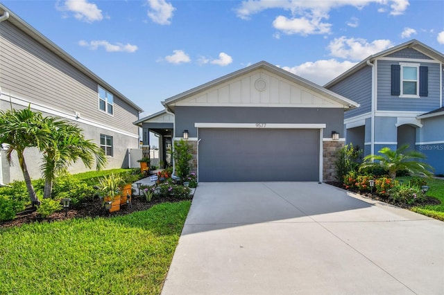 9577 Sandy Bluffs Cir, Parrish, FL 34219 - view of front of house featuring stone siding, concrete driveway, an attached garage, and board and batten siding