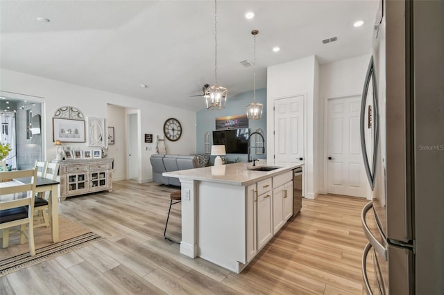 9577 Sandy Bluffs Cir, Parrish, FL 34219 - kitchen featuring a sink, appliances with stainless steel finishes, open floor plan, white cabinetry, and light wood-type flooring